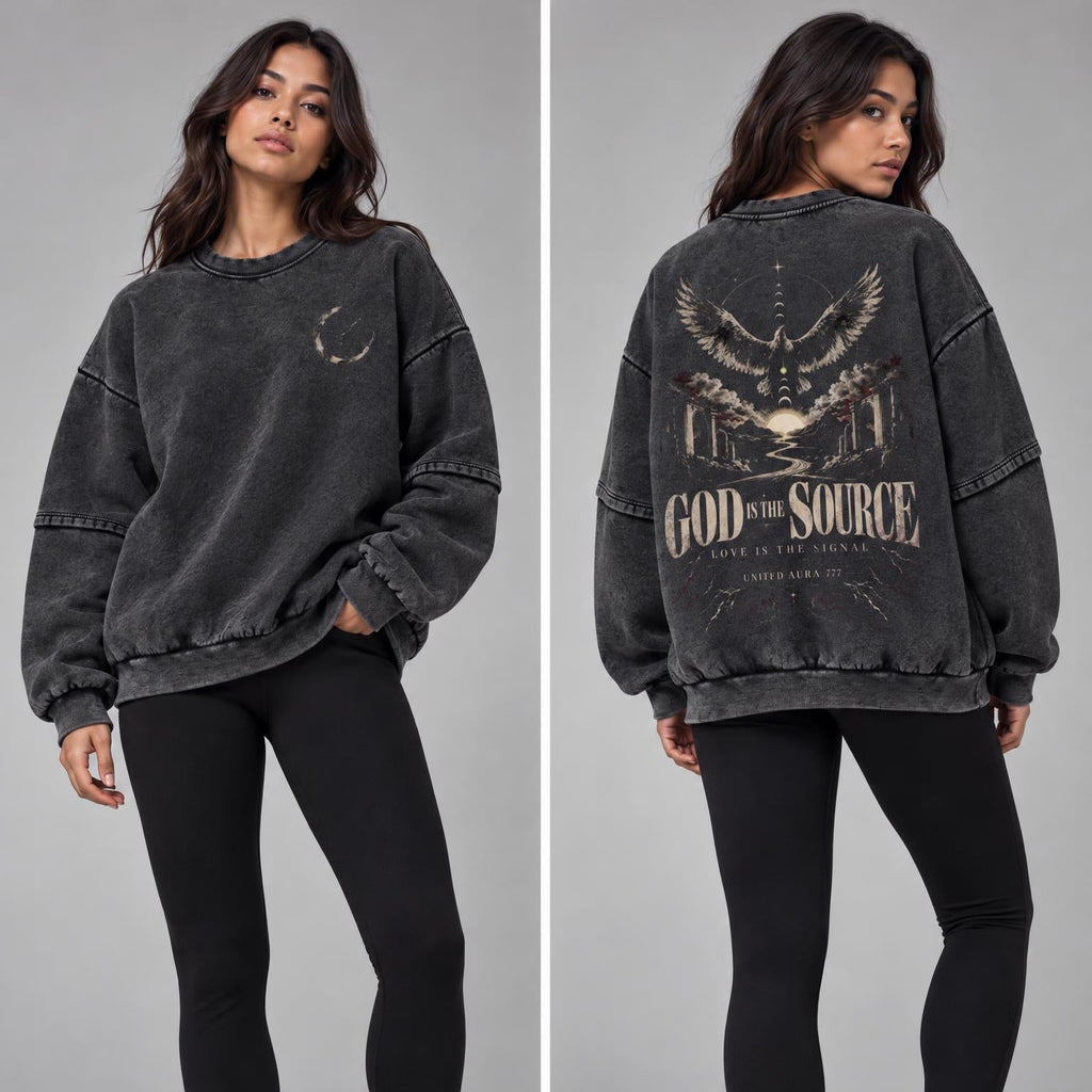 A split-view studio photo of a woman modeling a washed charcoal gray oversized sweatshirt with black leggings and white sneakers. The left view shows the front, and the right view shows the back, which features a large graphic with an eagle, a cross, and the text 'GOD IS THE SOURCE'.