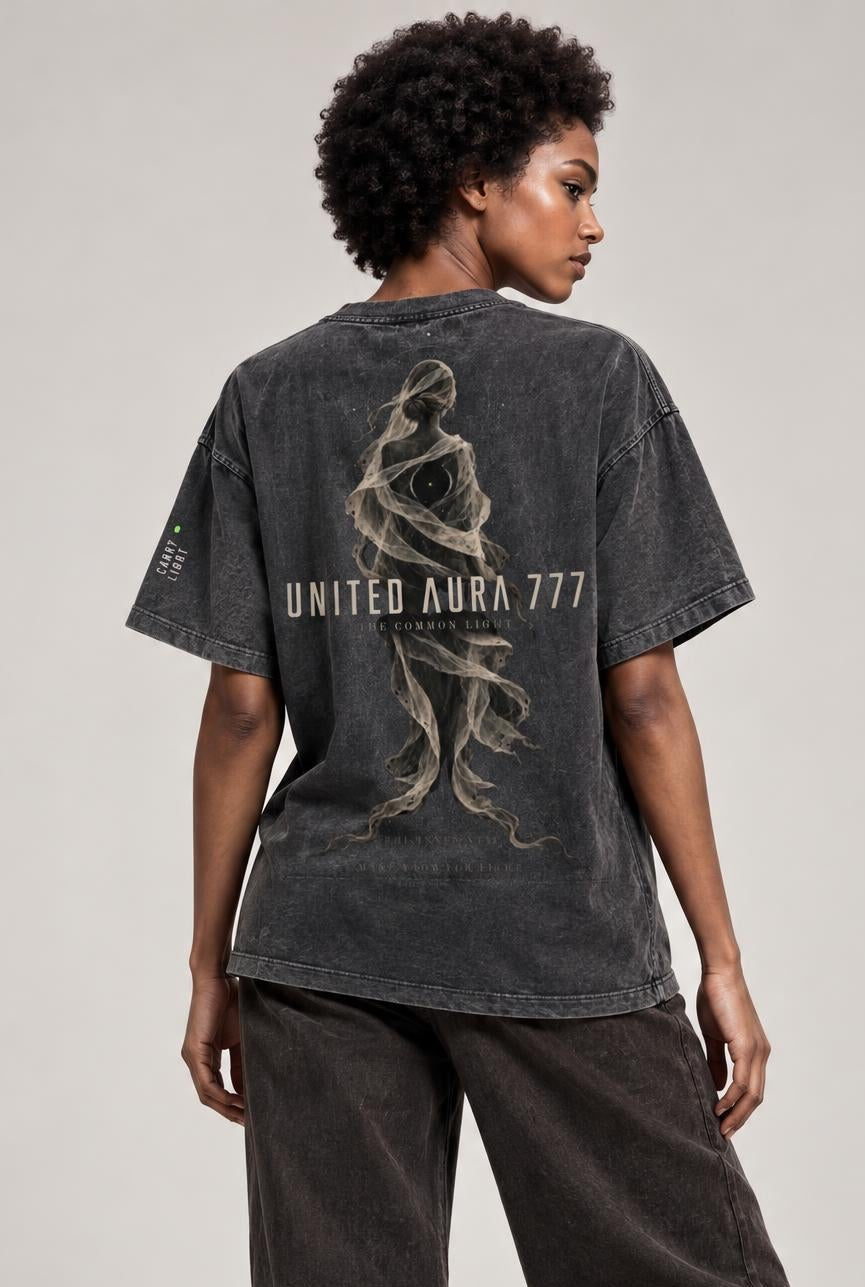 A model shown from the back wearing a faded black graphic t-shirt with 'UNITED ARMY 777' and a soldier silhouette, paired with dark wide-leg jeans and white sneakers, against a neutral studio background.