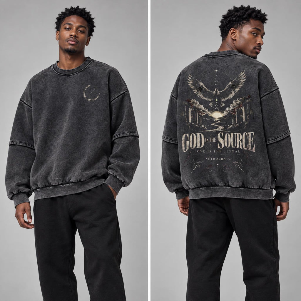 A model shown from the front and back wearing a washed black crewneck sweatshirt with a large graphic print on the back reading 'GOD IS THE SOURCE' and black sweatpants against a light gray studio background.