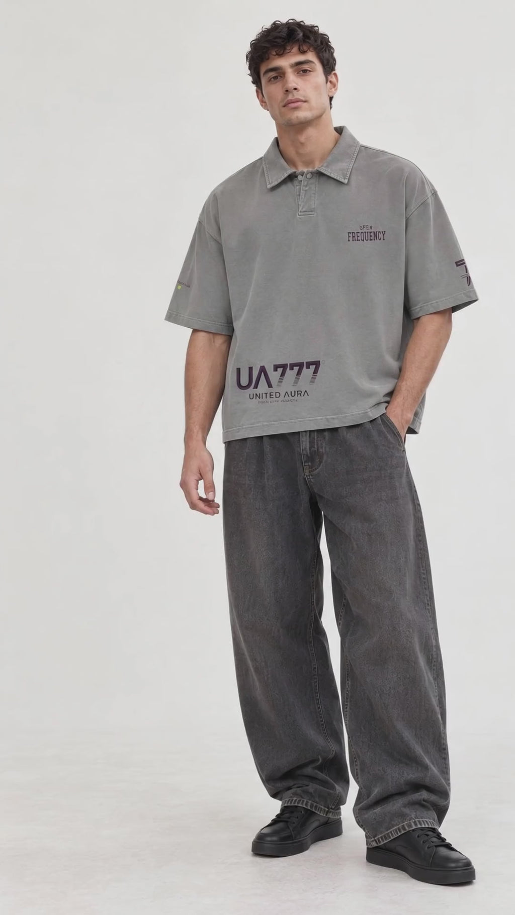 video of A man modeling a grey short-sleeve polo shirt with a cream-colored number 7 on the left chest, paired with matching navy drawstring pants and beige sneakers, against a plain light gray studio background.