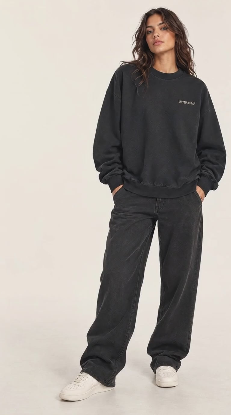 VIDEO OF A model shown from the back wearing a black crewneck sweatshirt with 'OPEN FREQUENCY CIRCLE' printed in white on the back, paired with black jeans and white sneakers, against a plain white studio background.